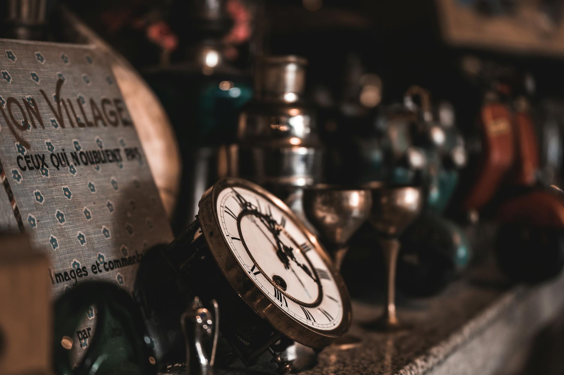 A close-up view of vintage clocks and antique items on a shelf, creating a nostalgic feel.