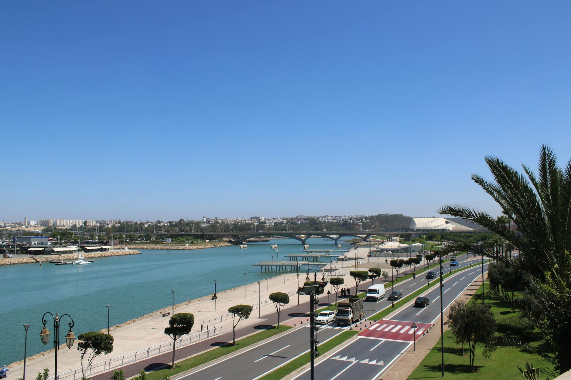Scenic view of Rabat's riverside featuring a bridge, clear sky, and urban landscape.